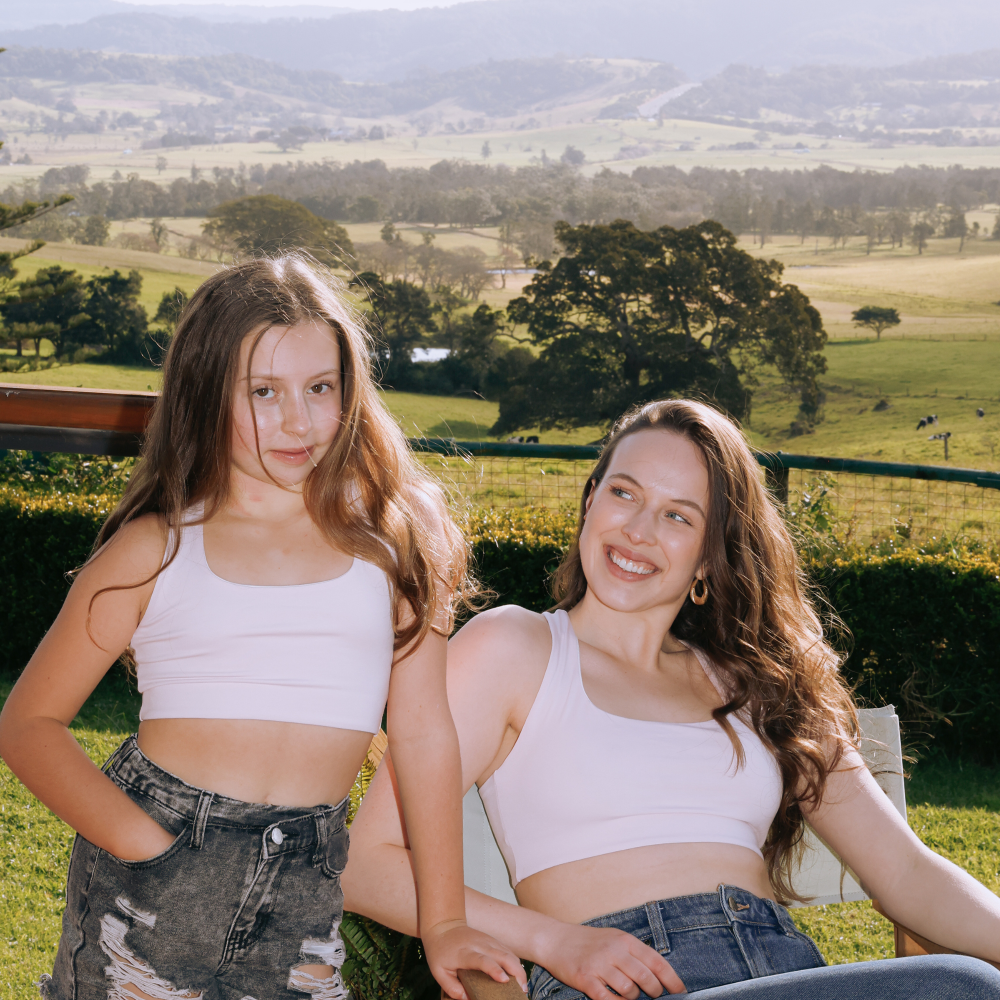 Two girls wearing reversible racerback crop bras